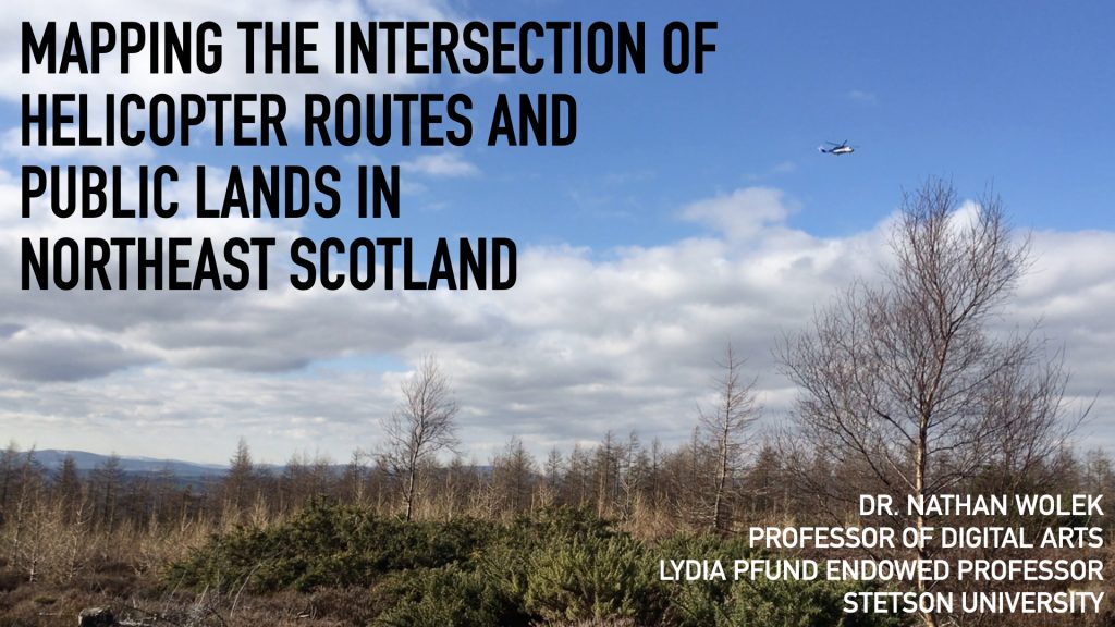 Title slide from presentation. Photo shows some leafless trees in the foreground with a distant helicopter flying off in the distance. Text reads: Mapping the intersection of helicopter routes and public lands in Northeast Scotland. Dr. Nathan Wolek, Professor of Digital Arts, Lydia Pfund Endowed Professor, Stetson University.